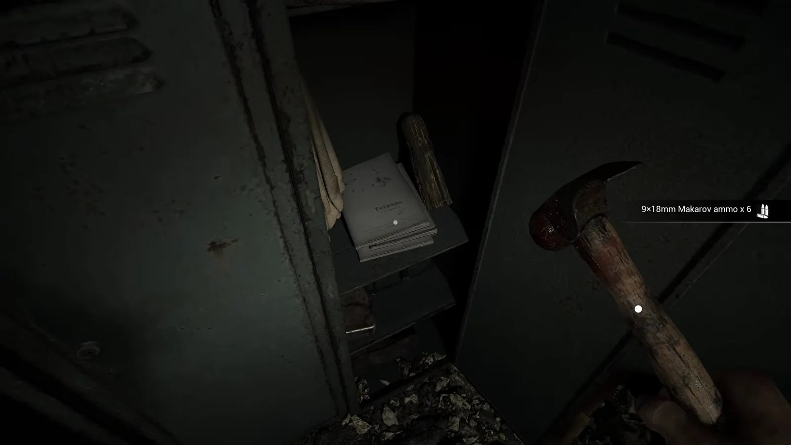 Hammer resting beside an open locker door with a paper note attached inside the locker shelf
